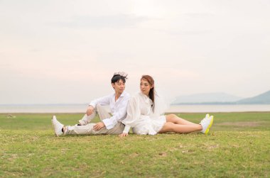 Gelin ve damat kıyafetli mutlu genç Asyalı çift evlenmeye ve evlenmeye hazır.