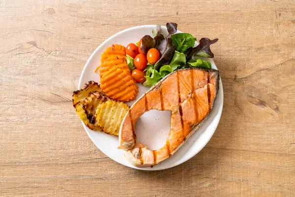 Kızarmış somon bifteği fileto, sebze ve patates kızartması.