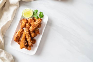Fried Snapper Belly on white plate - Asian food style