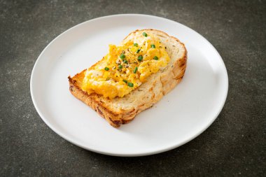 Ekmek tostu, çırpılmış yumurta ve beyaz tabak.