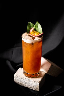 Kokteyl - fesleğen, tutku meyvesi ve tarçın, limon ve mango karıştırılmış koyu arkaplanda.