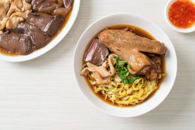 Kahverengi çorbada haşlanmış ördek ve haşlanmış yumurtalı şehriye Asya yemeği.