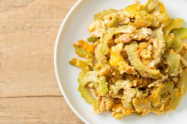 Kızarmış acı kabağı tabakta yumurta ile karıştır