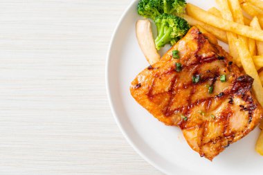 grilled chicken steak with potato chips or french fries on white plate