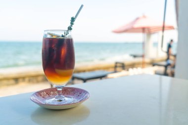 Okyanus arkaplanlı buzlu americano kahve şeftalisi.