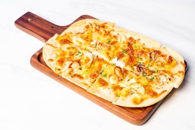 Tahta üzerinde turta alevli deniz ürünleri pizzası.