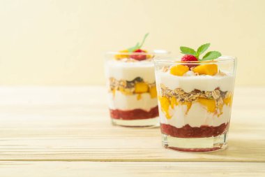Ev yapımı taze mango ve yoğurt ve granola ile taze ahududu. Sağlıklı yemek tarzı.
