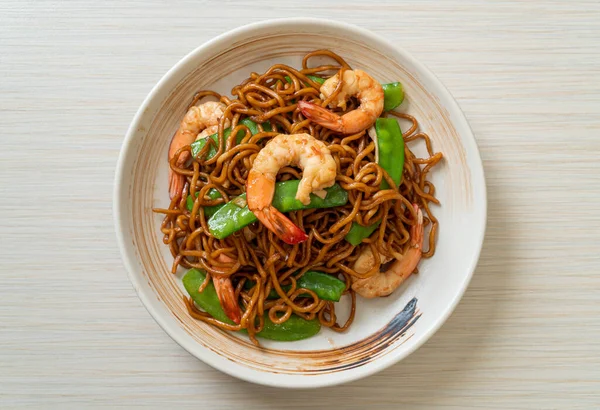 Kızarmış yakisoba eriştesi, yeşil bezelye ve karides, Asya usulü.