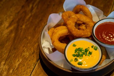 Ketçaplı soğan halkası ve tabakta sos.