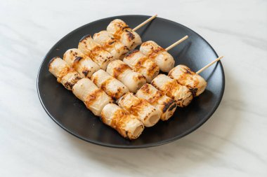 Izgara tüp şeklinde balık ezmeli kek ya da tabakta mürekkep balığı şişi.