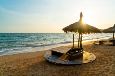 beach chair and umbrella with sea beach background at sunset time - Holidays and vacation concept