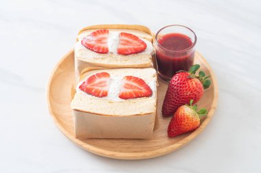 gözlemeli sandviç, çilekli taze krema, ahşap tabakta.