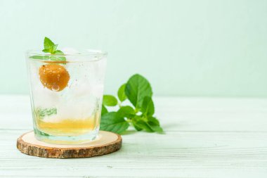 Sodayla buzlu erik suyu ve ahşap masada nane şekeri - içecek.