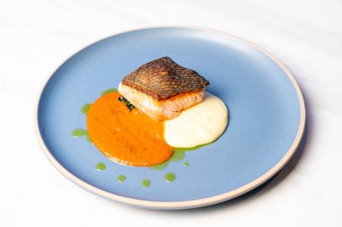 Izgara somon bifteği, patates püresi ve domates sosu.