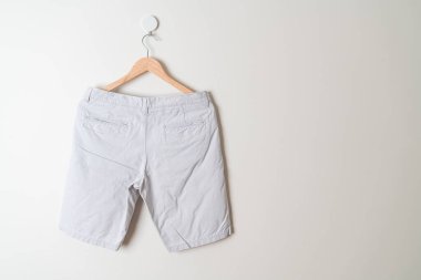 Kısa pantolon duvarda ahşap bir askıyla asılı.