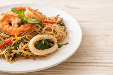 Fesleğenli, biberli, karidesli ve kalamarlı Çin eriştesi. Asya usulü.