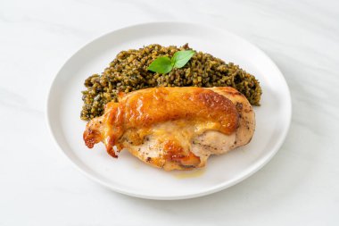 Kızarmış pesto pilavı ve beyaz tabakta kızarmış tavuk.