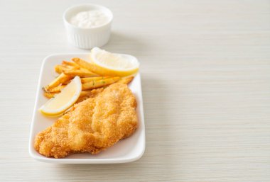 balık ve patates kızartması - kızarmış balık fileto patates cipsi ve limonlu beyaz tabak