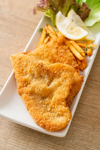balık ve patates kızartması - kızarmış balık fileto patates cipsi ve limonlu beyaz tabak