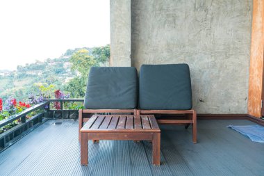 Dağ tepesi arka planında balkonda boş sandalye