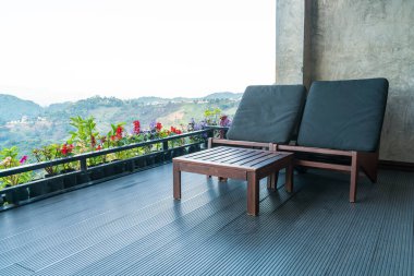 Dağ tepesi arka planında balkonda boş sandalye