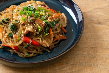 Japchae ya da karışık Kore vermicelli erişte sebzeli ve üzerine beyaz susamlı domuz eti - Kore geleneksel yemek tarzı