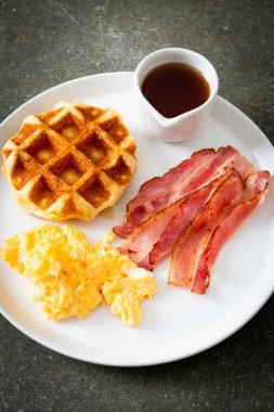 Kahvaltı için çırpılmış yumurta, pastırma ve waffle.