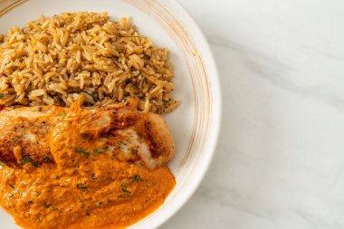 Kırmızı köri soslu ızgara tavuk bifteği ve pilav. Müslüman usulü.