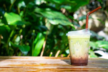 Buzlu yeşil çay, ahşap masadaki çikolatalı.