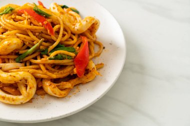 Kızarmış spagetti, tuzlanmış yumurta ve kalamar. Füzyon yemek stili.