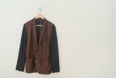 dark brown suit hanging with wood hanger on wall
