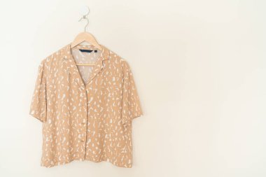 Duvarında ahşap askı asılı güzel bir kadın gömleği.