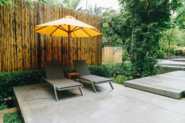 酒店度假胜地游泳池周围的雨伞和游泳池床装饰 — 图库照片