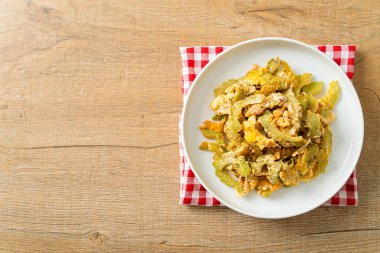 Kızarmış acı kabağı tabakta yumurta ile karıştır