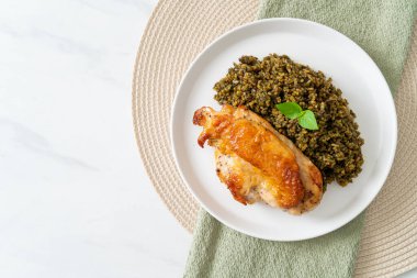 Kızarmış pesto pilavı ve beyaz tabakta kızarmış tavuk.