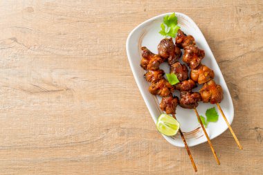 Izgara tavuk şişi. Tabakta baharat ve şifalı otlar var.