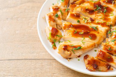 Izgara ballı tavuk göğsü. Beyaz tabakta dilimlenmiş.