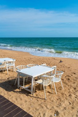 empty dinning table and chair on beach with sea background