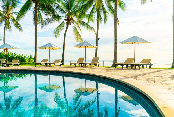宾馆室外游泳池周围有漂亮的豪华雨伞和椅子 日落或日出时带椰子树的度假胜地 假日和度假理念 — 图库照片