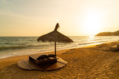 beach chair and umbrella with sea beach background at sunset time - Holidays and vacation concept