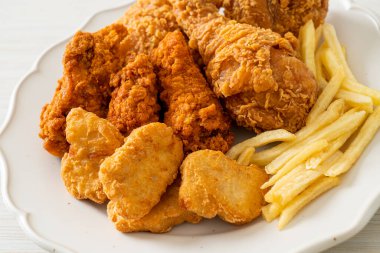 Patates kızartmalı kızarmış tavuk ve tabakta nugget - sağlıksız yemek.