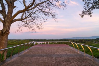 Balkonda çay çiftliği ve alacakaranlık gökyüzü var.