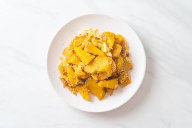 Beyaz tabakta yumurtalı kızarmış balkabağı.