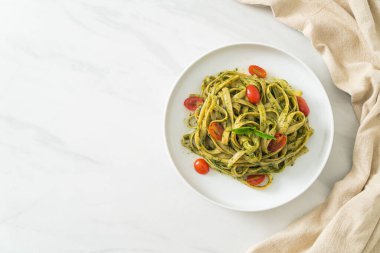pesto soslu ve domatesli makarna vejetaryen ve vejetaryen yemek tarzı.