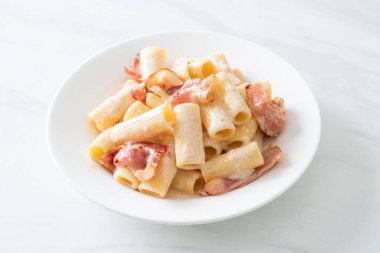 Beyaz soslu ve pastırmalı ev yapımı spagetti rigatoni makarna. İtalyan usulü.