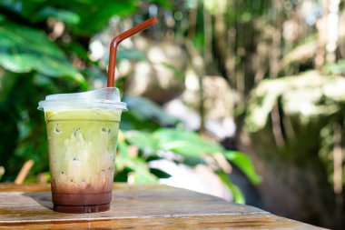 Buzlu yeşil çay, ahşap masadaki çikolatalı.