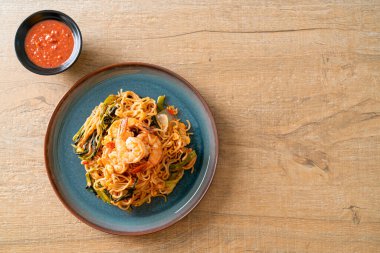 Karıştırılmış hazır erişteli sukiyaki, karidesli, Asya usulü.