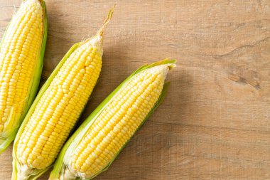 fresh corn on wood background with copy space