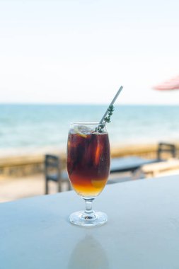 Okyanus arkaplanlı buzlu americano kahve şeftalisi.