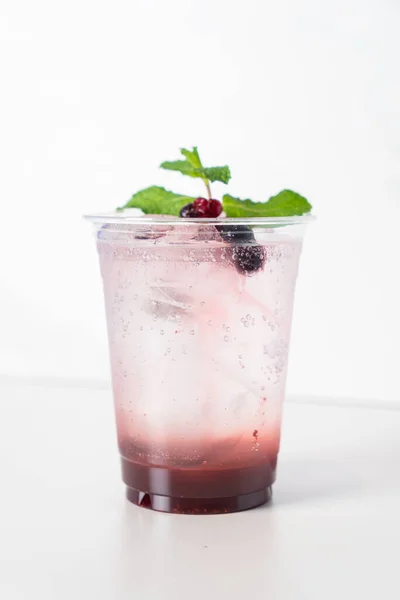 mix berry with soda in glass with mint on top